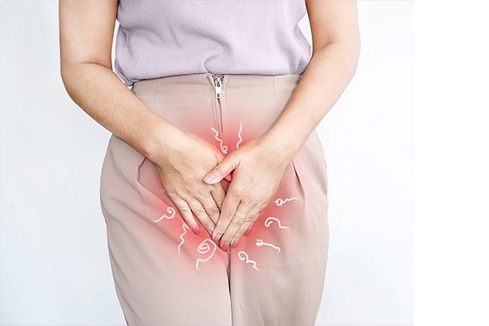 A woman appears uncomfortable as she touches her lower abdomen or groin area, symbolizing vaginal itching. The image reflects discomfort caused by common conditions like yeast infections, irritation, or hormonal changes.