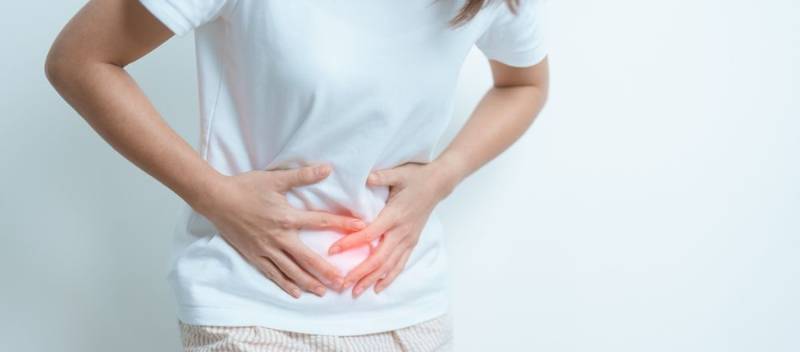 Illustration of a female experiencing pelvic pain caused by endometriosis, highlighting inflamed tissue outside the uterus