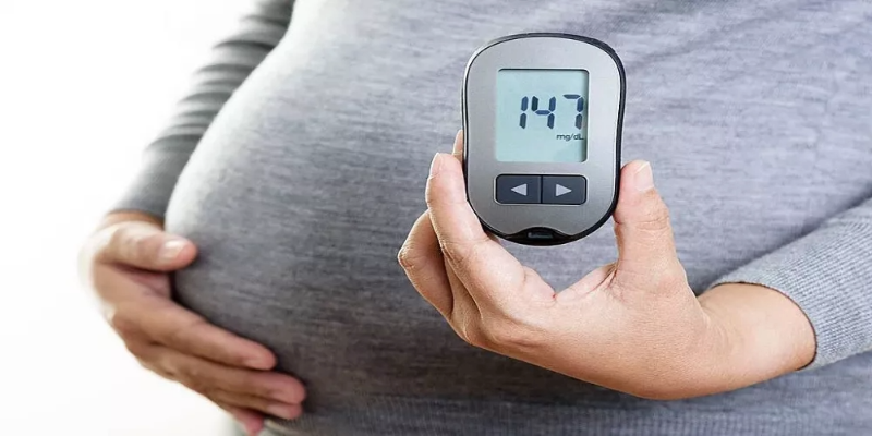 Pregnant woman standing with one hand on her belly and a thoughtful, concerned expression, symbolizing the struggles of gestational diabetes