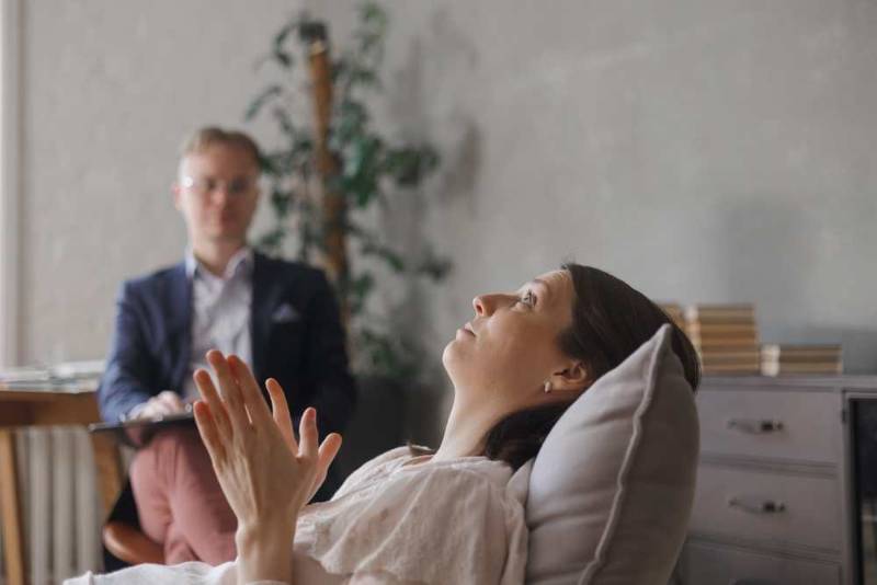 A young woman discussing with her doctor the most important strategies for coping with Generalized Anxiety Disorder, focusing on therapy, lifestyle changes, and relaxation techniques