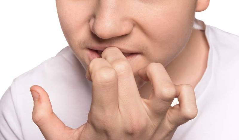 A person struggling with nail biting, highlighting the habit, its stress triggers, and the impact on Psychological health