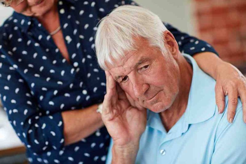 Person sitting , holding their head in anxiety, illustrating the fear of death (Thanatophobia) and emotional distress associated with mortality fears
