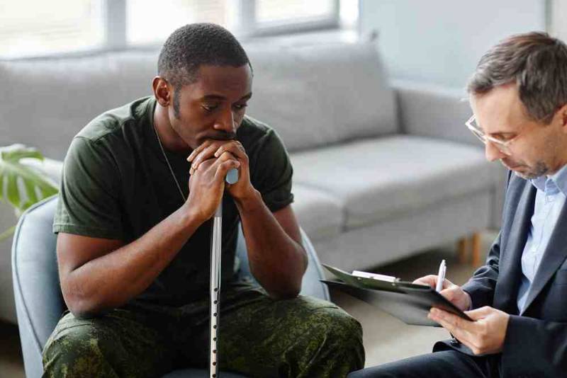 A compassionate doctor talking with a patient, providing professional care and support to help manage and treat post-traumatic stress disorder (PTSD)