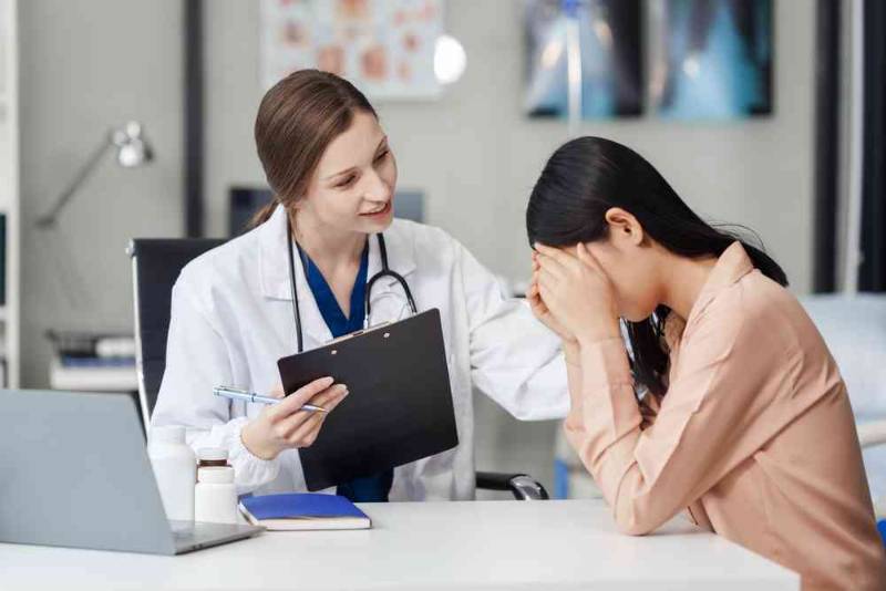 A therapist and patient sitting face-to-face in a calm office, engaging in a Cognitive Behavioral Therapy (CBT) session, with the therapist taking notes and the patient expressing emotions